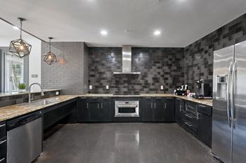 Modern kitchen with dark cabinetry and checkered backsplash